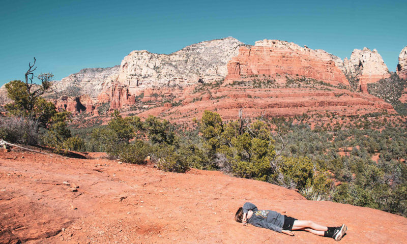 Photo of a young hiker laying down on the trail